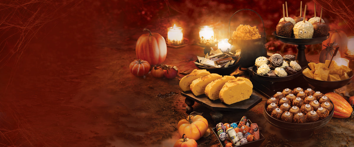 Image of Assortment of Halloween themed Kilwins Products such as Fudge, Buckeyes, Chocolates, Caramel Apples and more. 