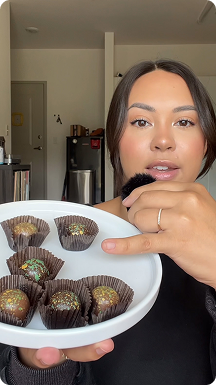Woman holding a plate of Kilwins Dubai chocolate truffles