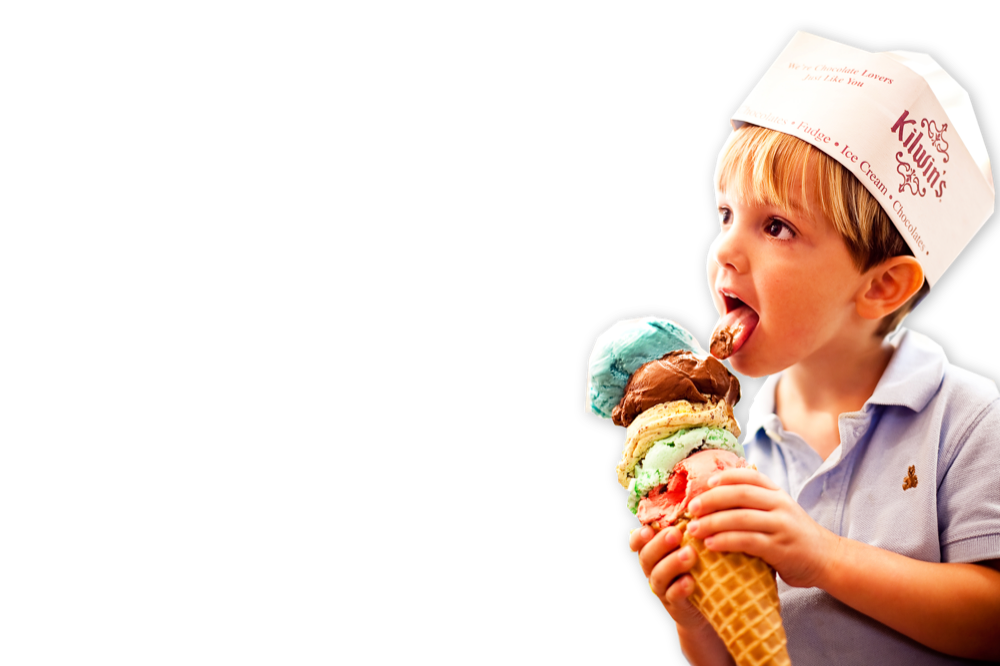 Photo of child wearing Kilwins hat licking Ice Cream Waffle Cone