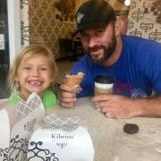 A picture of a man and a child enjoying ice cream and hot chocolate at Kilwins San Antonio 