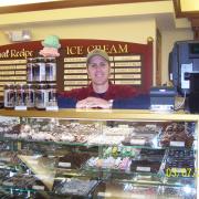A picture of the owner behind the chocolates case