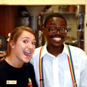 Photo of female Team Member smiling with man wearing rainbow suspenders