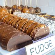 Photo of loaves of Fudge in Fudge Case with Caramel Apples in background